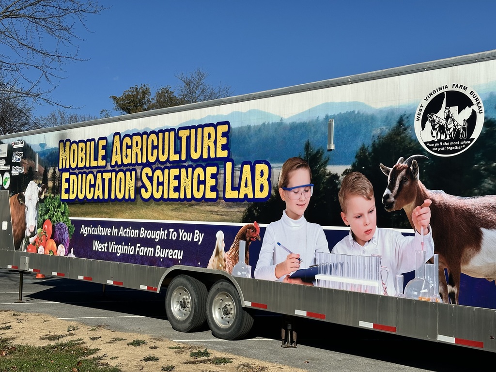 The exterior of the Mobile Agriculture Education Science Lab Bus. There are images of livestock animals and students doing science experiments.
