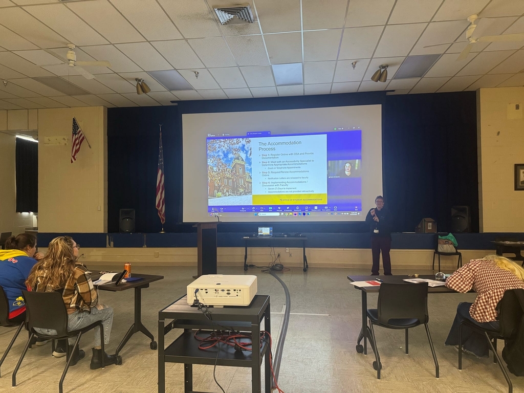 Participants observe a presentation using a large screen on "the accommodation process."