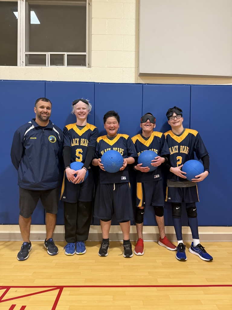 Group photo of the boy's goalball team with their coach.