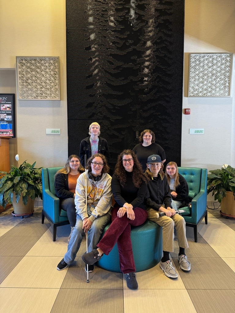 A group of students and Ms. Rachel Lanham are seated for a photo at the National Federation of the Blind Conference.