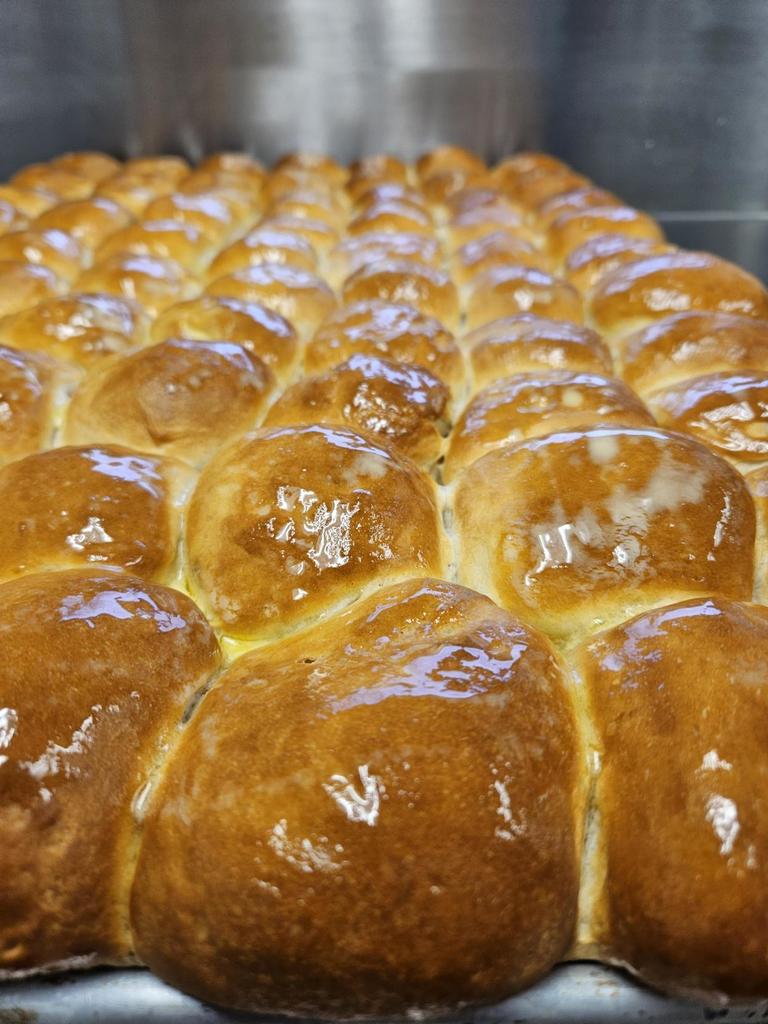 Up-close photo of buttery roles sitting on a pan.