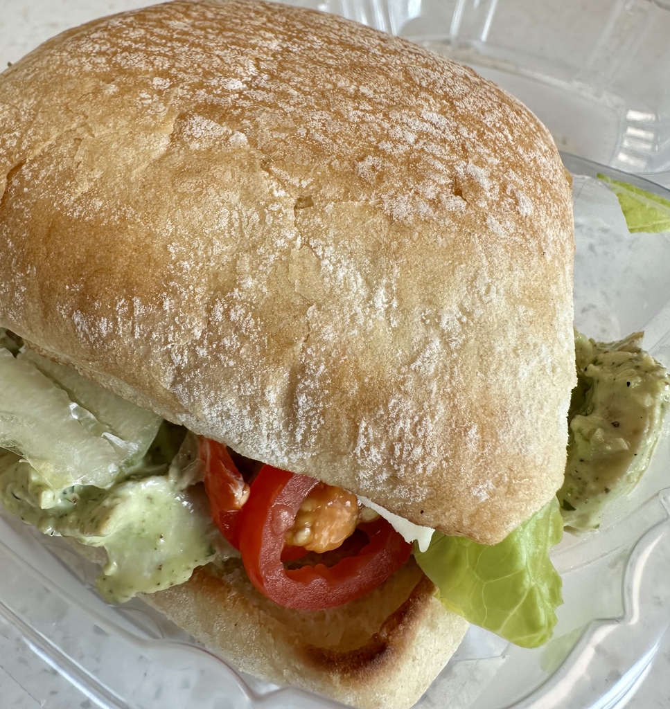 Up-close of a chicken salad sandwich with lettuce and tomatoes. 