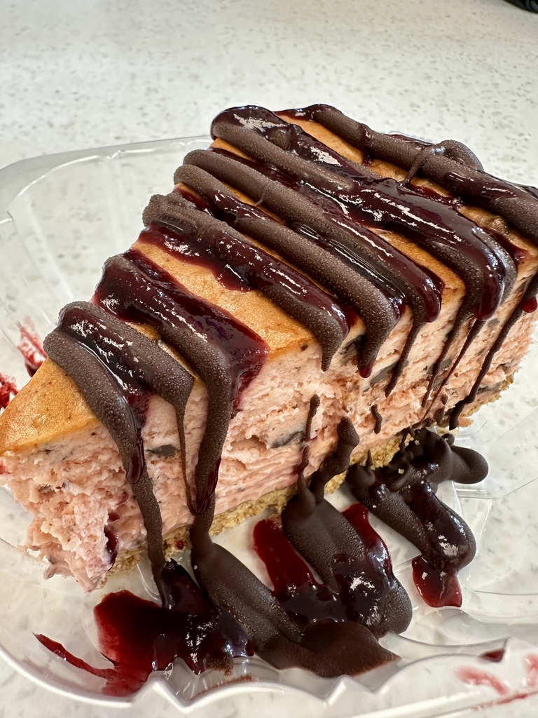 Strawberry cheesecake drizzled with chocolate sauce. 