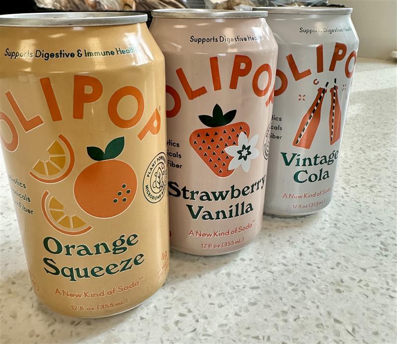 Three flavors of canned beverages. Flavors include Orange Squeeze, Strawberry Vanilla, and Vintage Cola. 