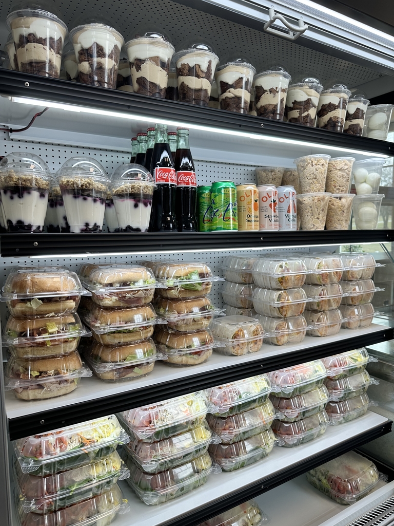 Overview of items stocked in a refrigerator in the Appalachia Provisions Cafe. Items include sandwiches, salads, wraps, and beverages.