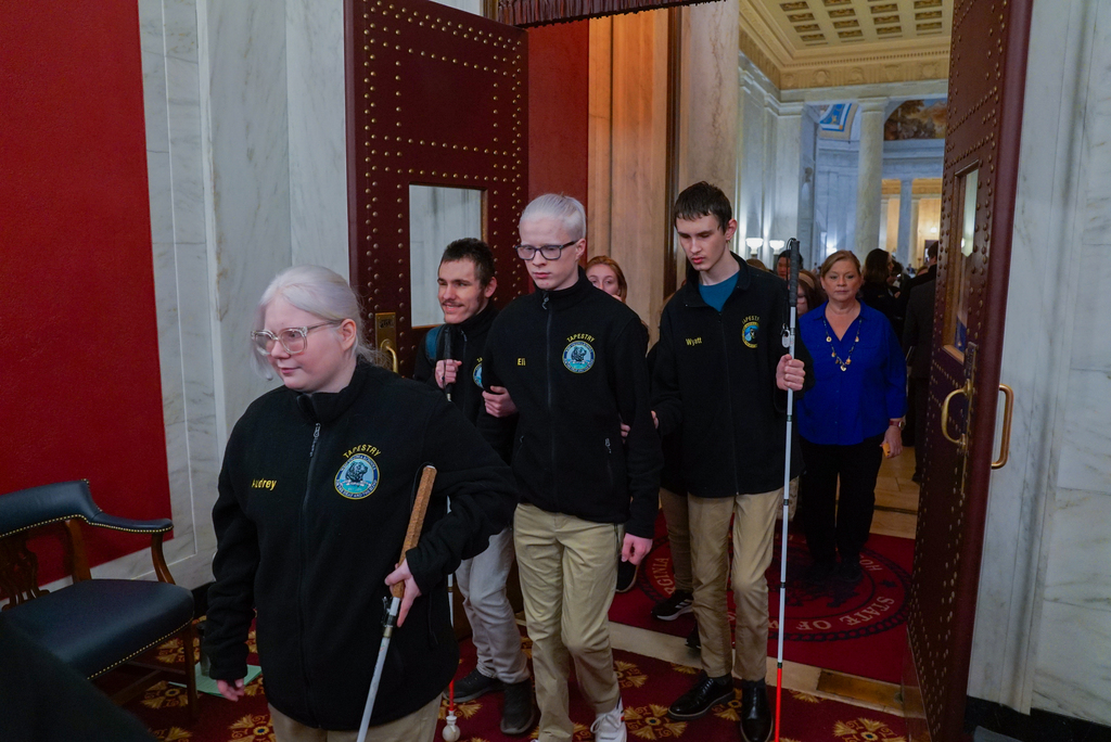 A group of WVSDB students walking into the Legislature using their canes to navigate their way.