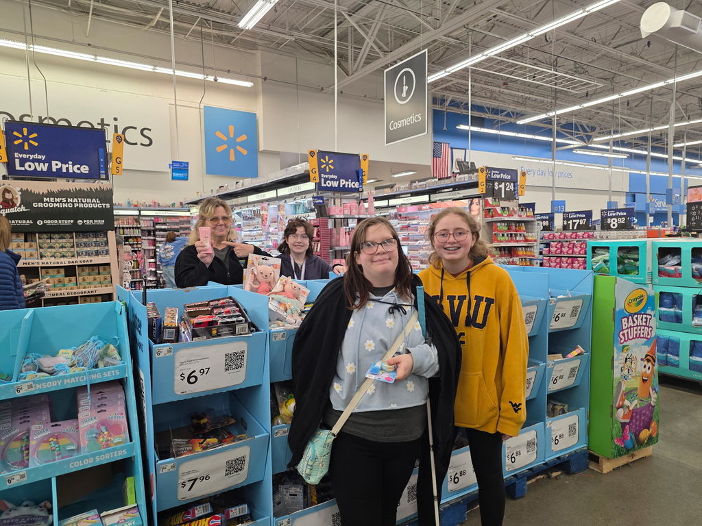 Female students and a female WVSDB representative smile for the camera.