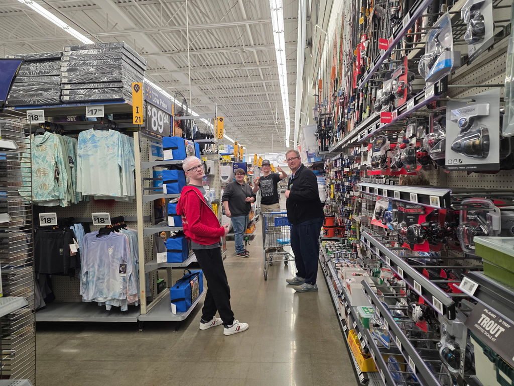 Male students and a male WVSDB representative look back for the camera as they shop.