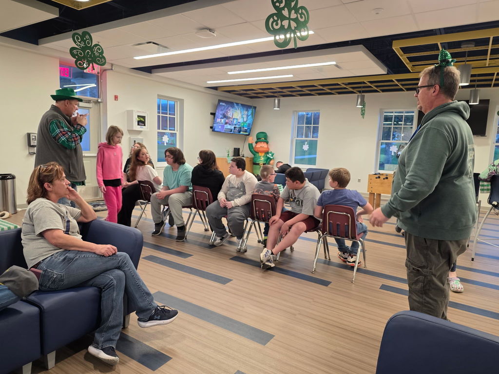 Students in the Blue and Gold Student Union are seated on burgundy-colored chairs as they play musical chairs. 
