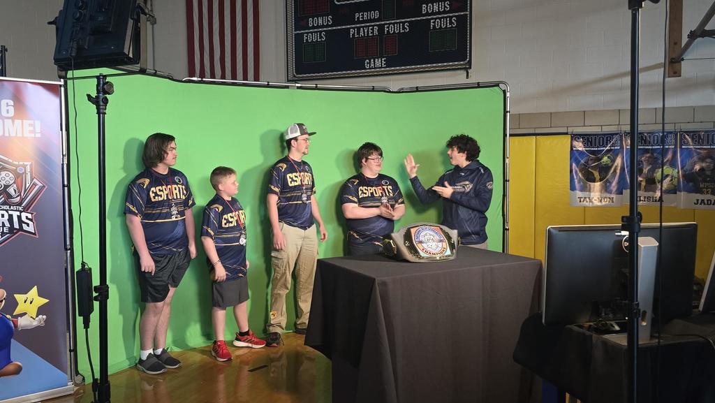The Fortnite championship winners stand side-by-side in front of a green screen as they are being interviewed by an individual using ASL.