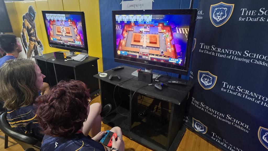 Two Esports players sit side-by-side as they compete against one another.