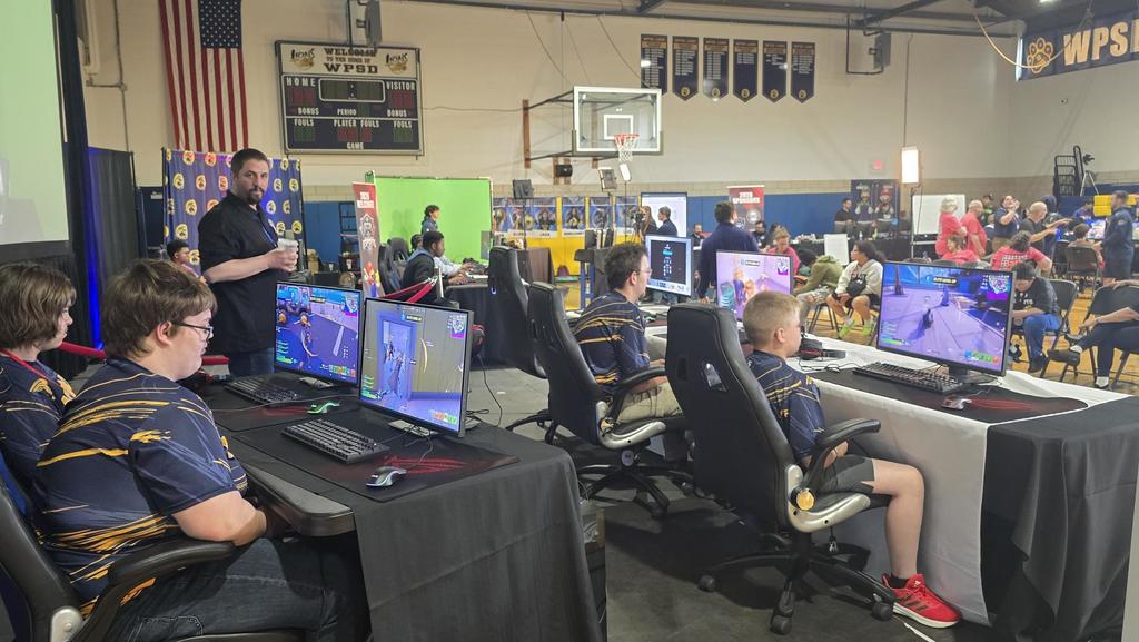 Esports players set in front of computer monitors and compete against one another.