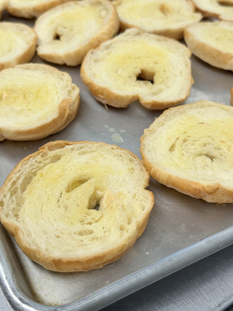 Buttery Croissants sitting on a sheet pan.