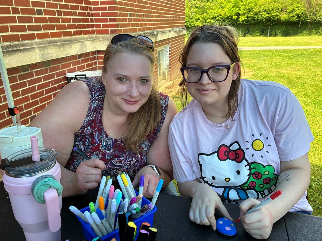 Mrs. Christina Payne and female student, Bindi, smile for the camera while they work on crafts.