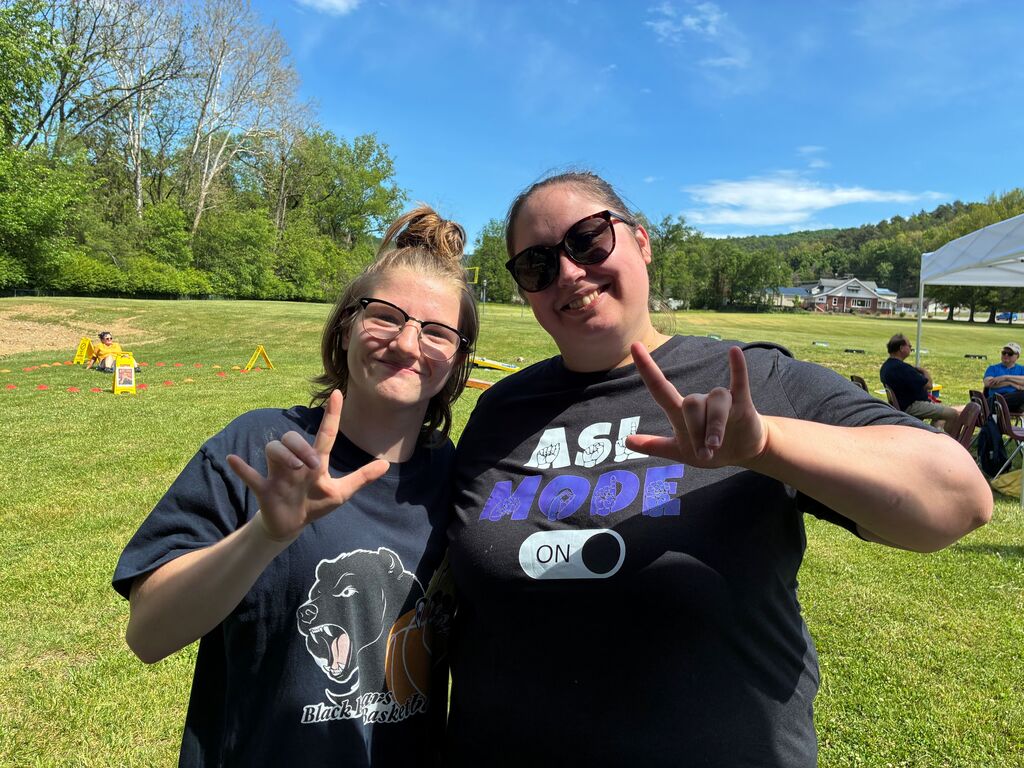 Skylar and Holly, both hold up the "I love you" sign in ASL.