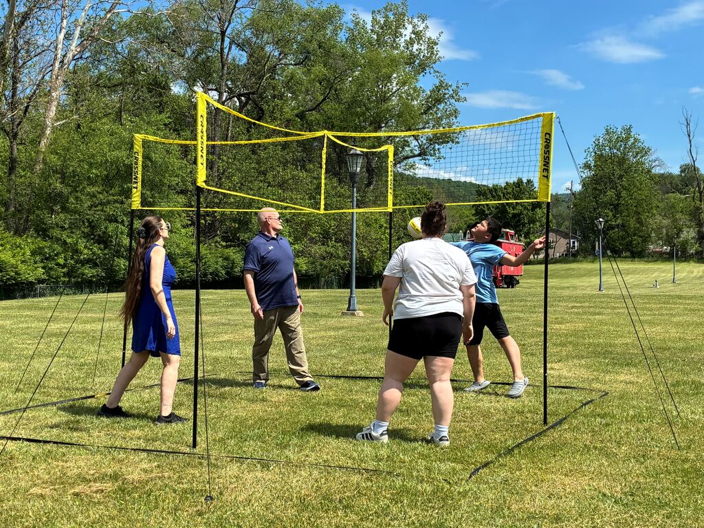 Participants are gathered around and play an outdoor game.