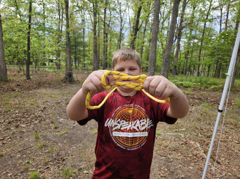 Aiden, holds up a yellow rope with a knot he created.