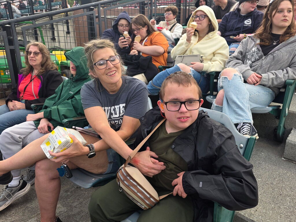 Nurse Tonya, is seated beside a male student, Jayden. There are secondary students sitting behind them.