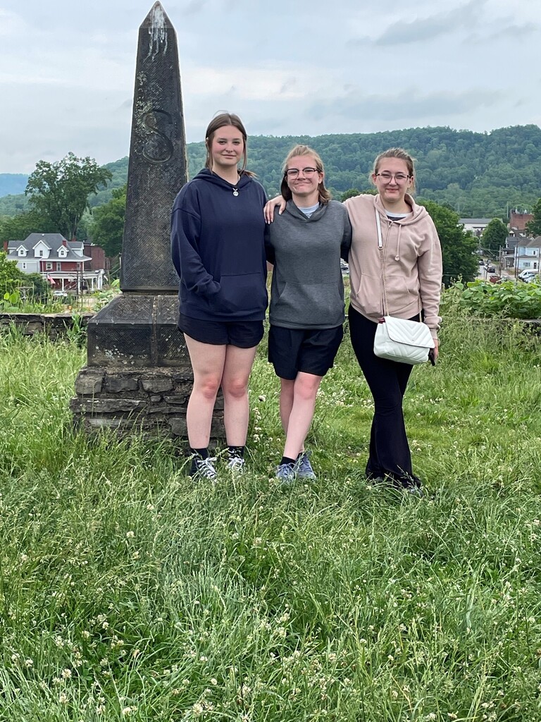 Three WVSDB seniors, Bray, Madison, and Skylar stand side-by-side in front of the Grave Creek Mound.