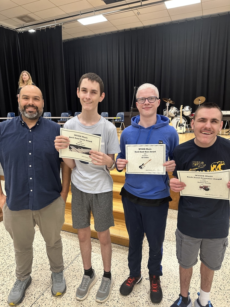 Mr. Haza stands next to WVSDB Rock Band members, Wyatt, Eli, and Hunter. The three band members are holding up their certificates of achievement.