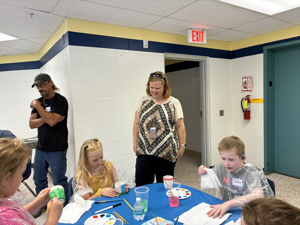 Dean Hesse smiles as she observes attendees participating in a crafting session.