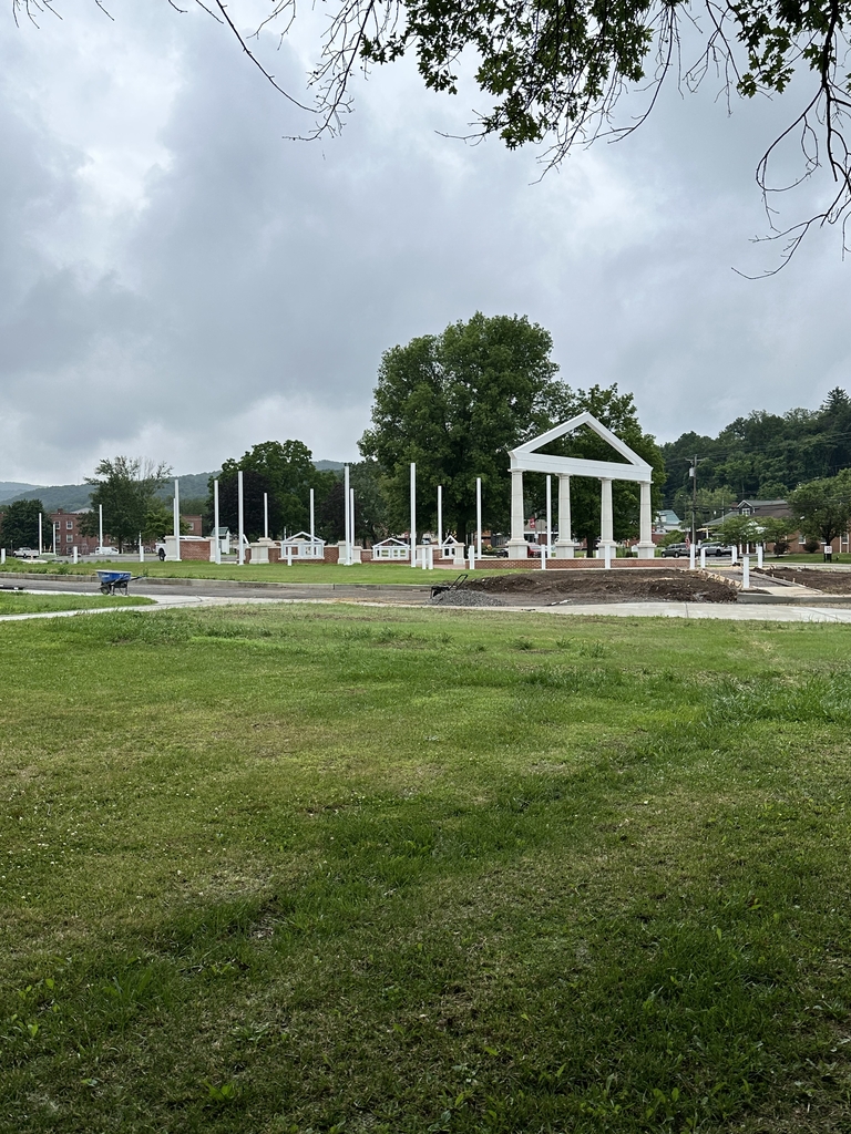 Construction progress on the WVSDB Administration Building Memorial featuring white columns, flagpoles, and landscaped walkways.