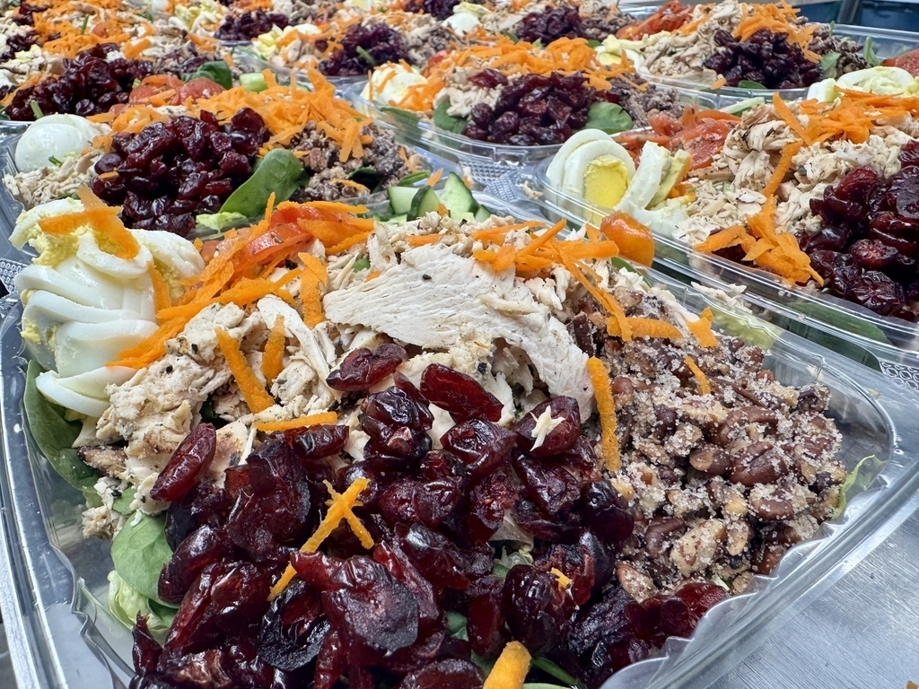 Fresh cranberry pecan chicken salads topped with chicken, dried cranberries, carrots, hard-boiled eggs, and mixed greens, prepared for customers at Appalachia Provisions Café.