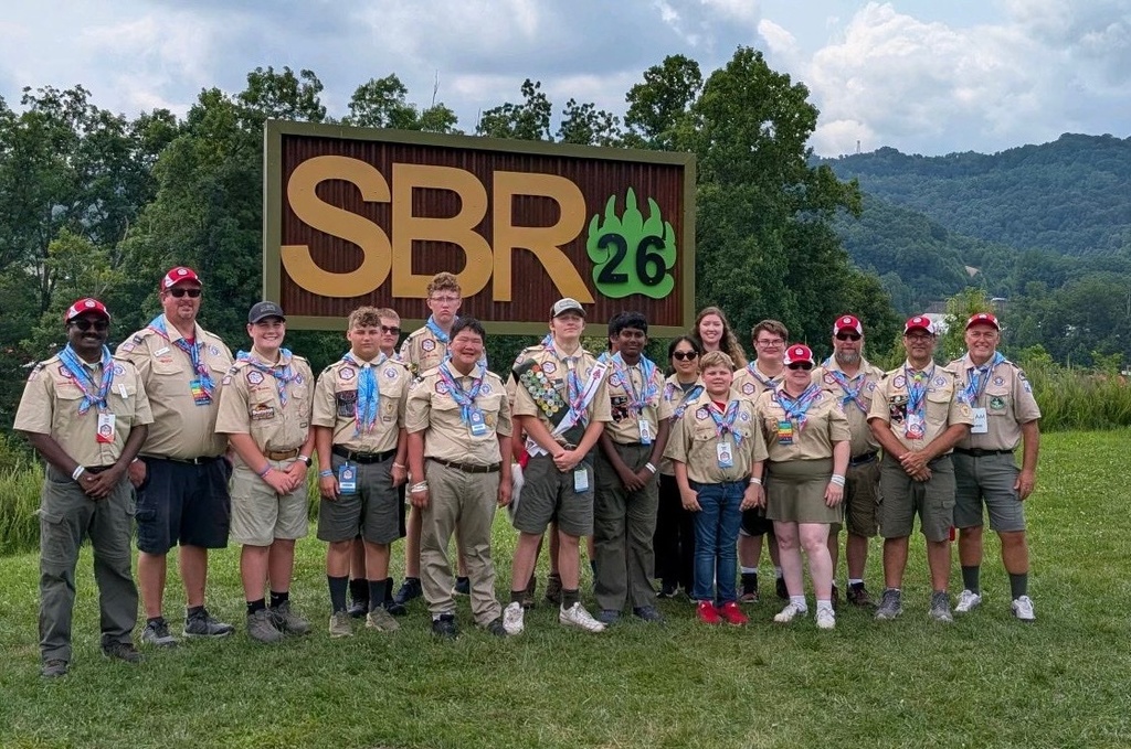 WVSDB Boy Scouts and troop leaders pose for a group photo in front of the National Scout Jamboree entrance sign.