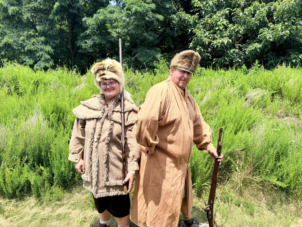 A WVSDB Boy Scout and a WVSDB staff members dressed in frontier-era clothing pose together during a primitive tanning demonstration at the National Scout Jamboree.