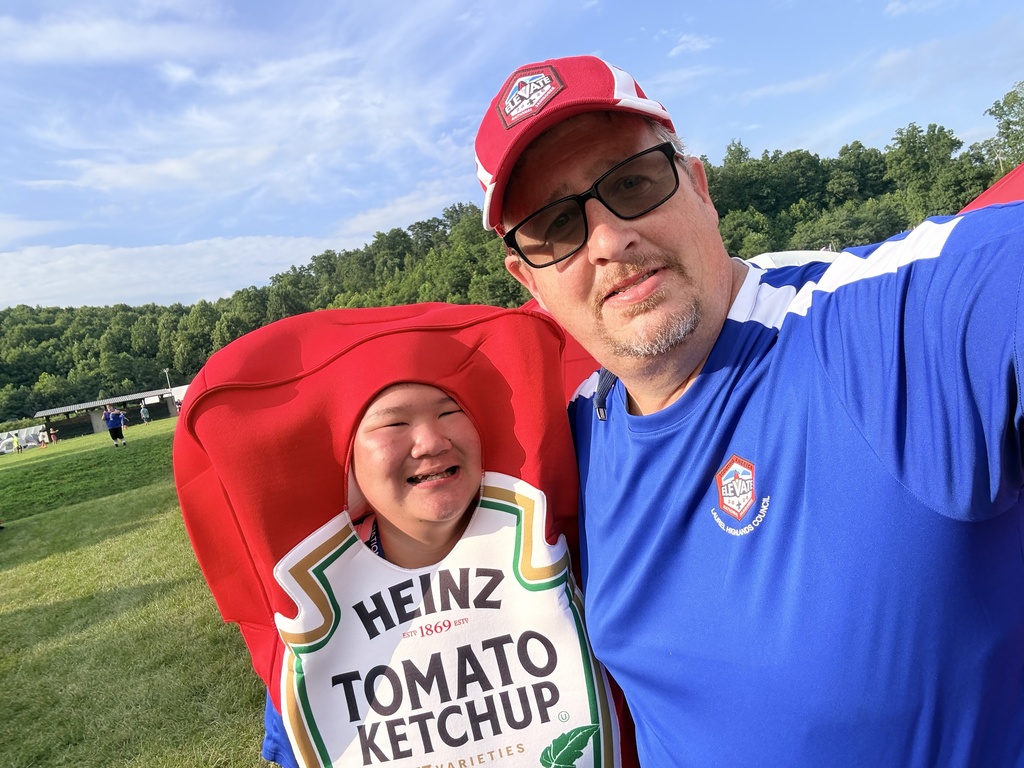 A WVSDB Boy Scout and a WVSDB staff member for a photo with the Scout dressed in a Heinz ketchup costume during a special campfire dinner sponsored by the Heinz Corporation.