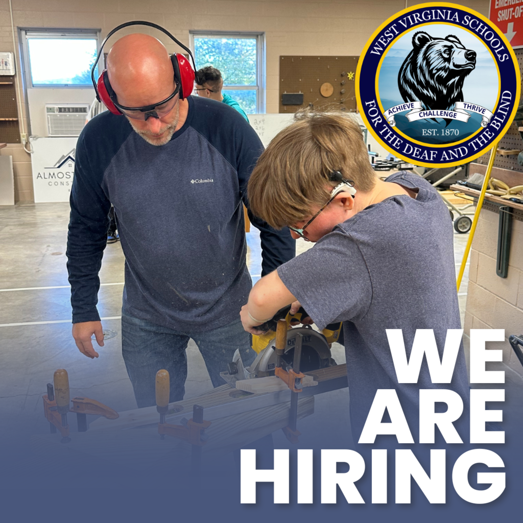 Teacher assisting student with board saw with we are hiring banner and bear logo