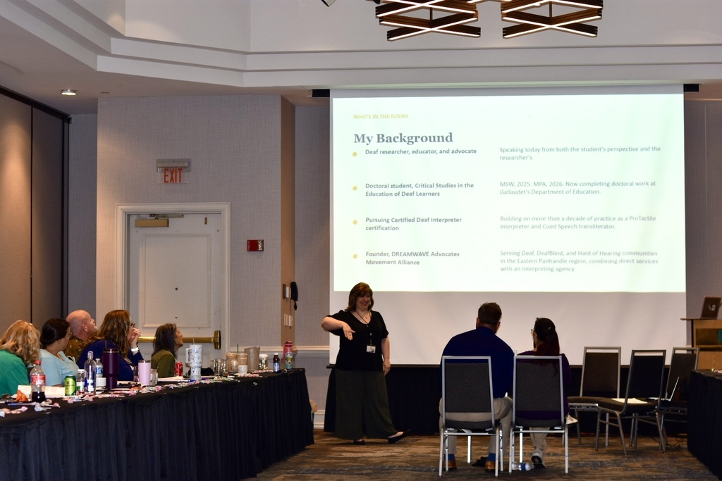 A presenter leads a session at the 2026 WVSDB Interpreter Summit as attendees watch from tables throughout the conference room.