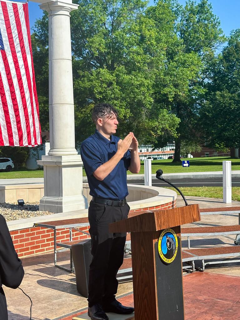 Interpreter provides sign language access beside the podium during the WVSDB Administration Building Memorial dedication ceremony.