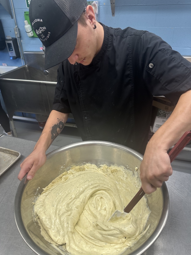 Appalachia Provisions student mixes ingredients in a large bowl while preparing food in the café kitchen.