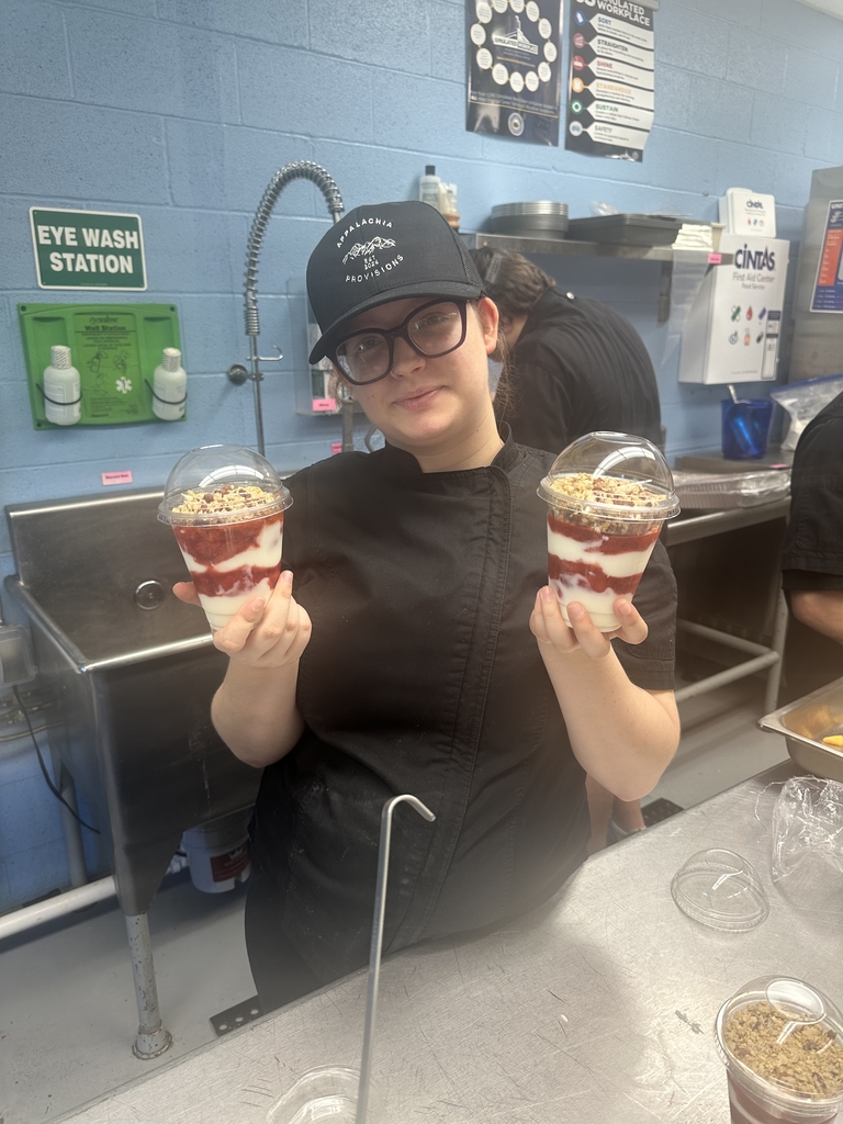 Appalachia Provisions student holds two freshly prepared strawberry pecan yogurt parfaits.