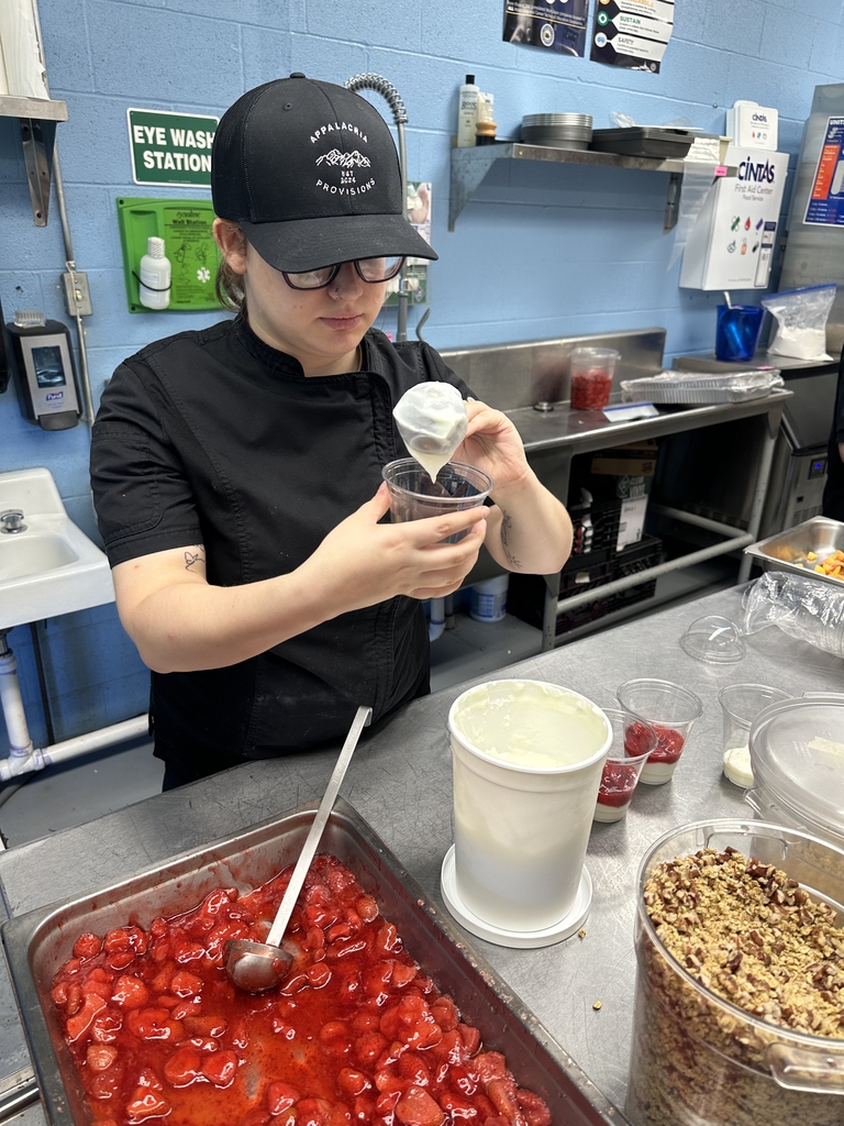 Appalachia Provisions student layers yogurt into cups while preparing strawberry pecan yogurt parfaits.