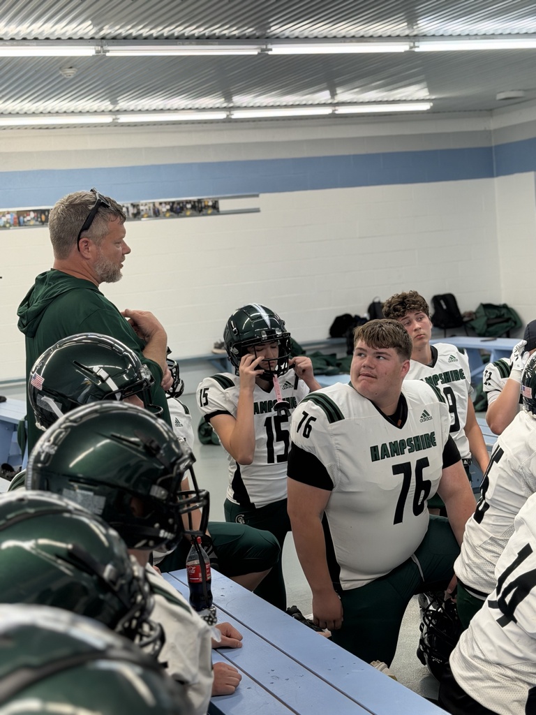 WVSDB student Carson, number 76, stands with his Hampshire High School football teammates in the locker room as the team prepares for a game.