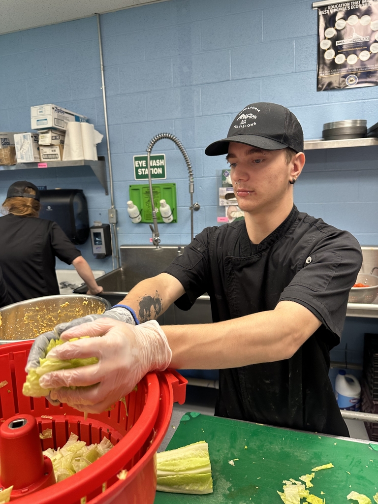Appalachia Provisions culinary student transfers freshly chopped romaine lettuce into a salad spinner while working in the café kitchen.