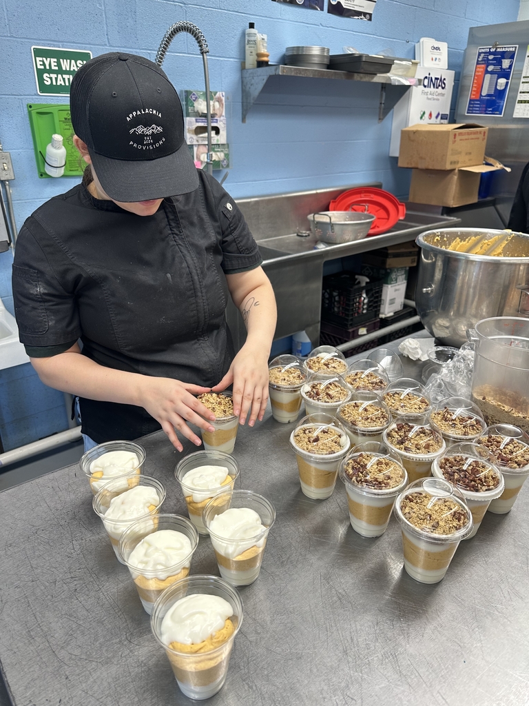 Appalachia Provisions culinary student prepares a large batch of pumpkin pecan yogurt parfaits, topping individual cups with granola and pecans.