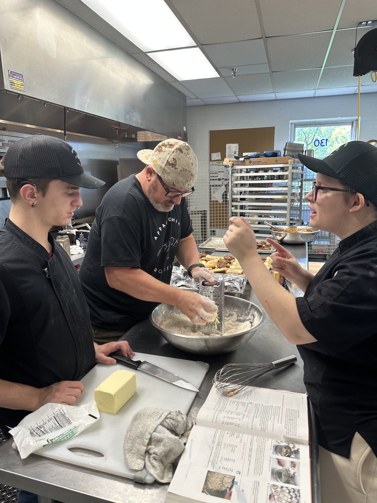 Appalachia Provisions culinary students work alongside their instructor while preparing ingredients in the kitchen.