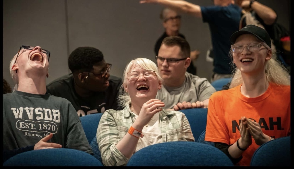 Students laugh together while seated in an auditorium during their SCIVIS Space Camp experience.