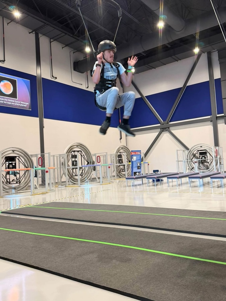 WVSDB student wearing a helmet and safety harness suspended above the floor during a Space Camp training activity.