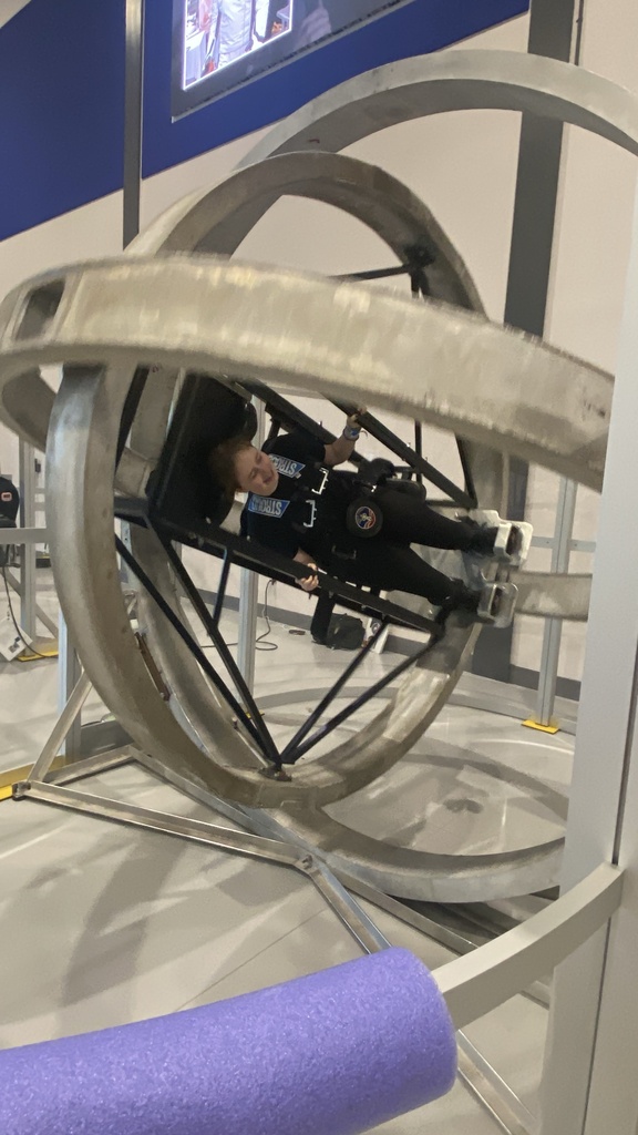 WVSDB student experiencing a multi-axis rotation simulator as the rotating rings turn her sideways during a Space Camp activity.