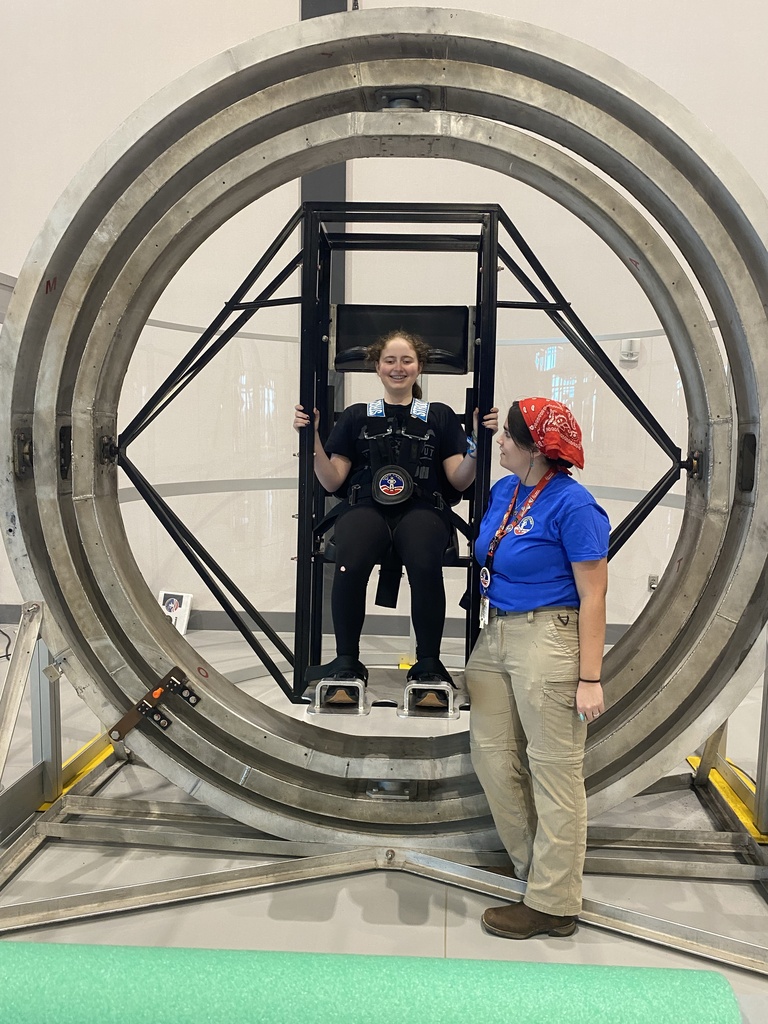 WVSDB student seated and secured inside a multi-axis rotation simulator at Space Camp while an instructor stands beside her.