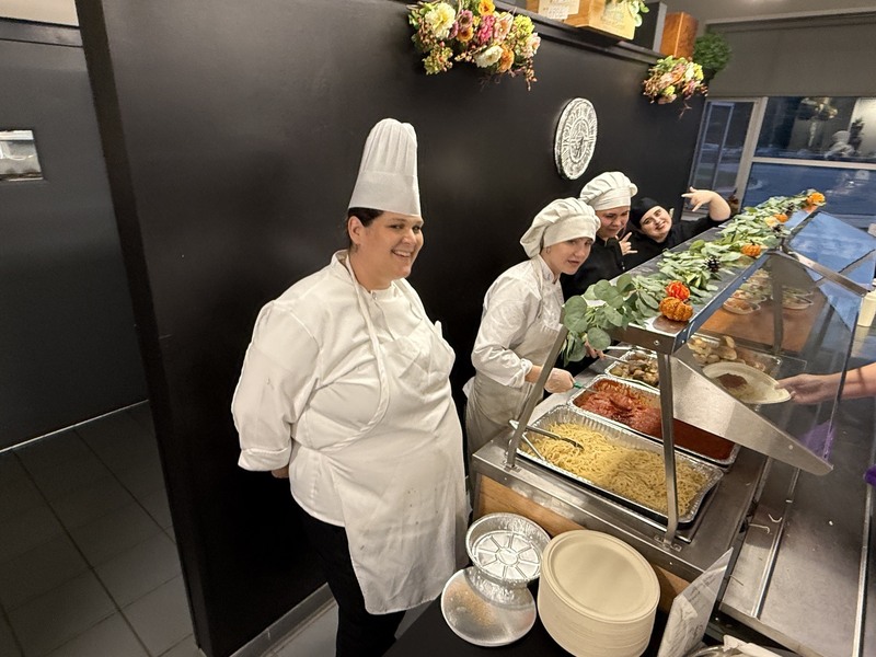 Chef and culinary arts volunteer students serving dinner for our advisory committees