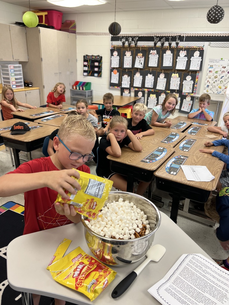 Student pouring marshmallows into mixing bowl in class.