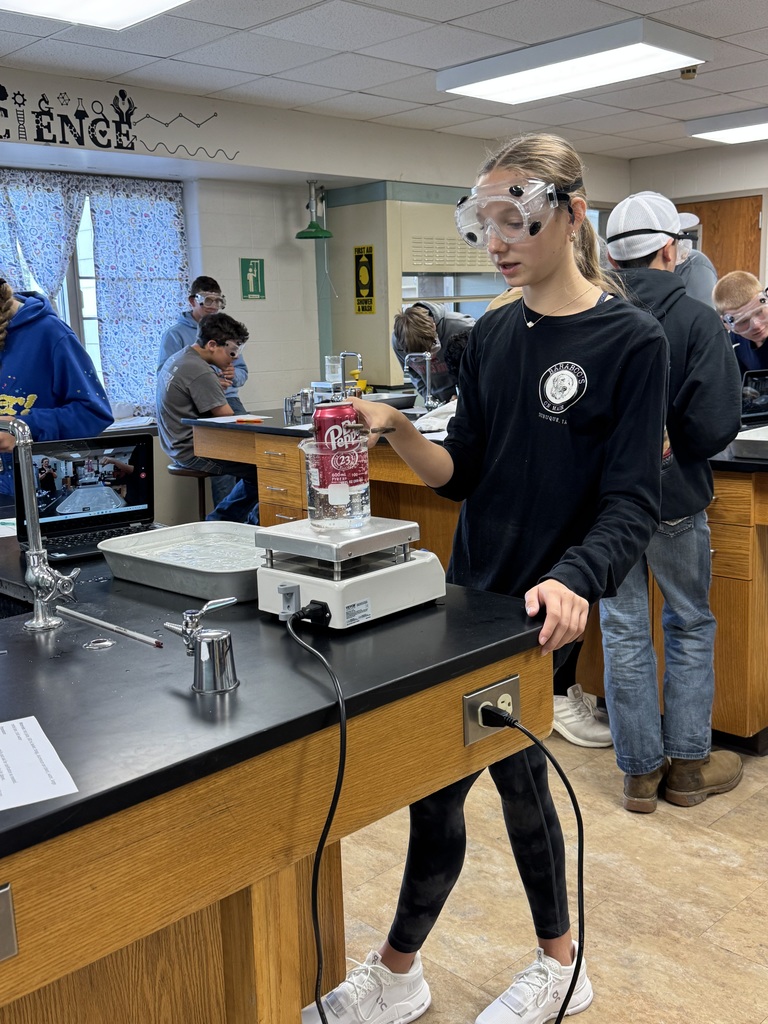 Student in goggles preparing a Dr. Pepper can science experiment in the lab