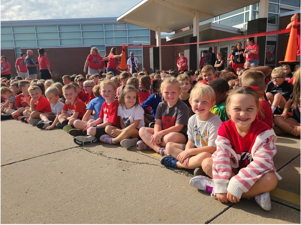 Students sitting in front of the school preparing to watch the homecoming parade