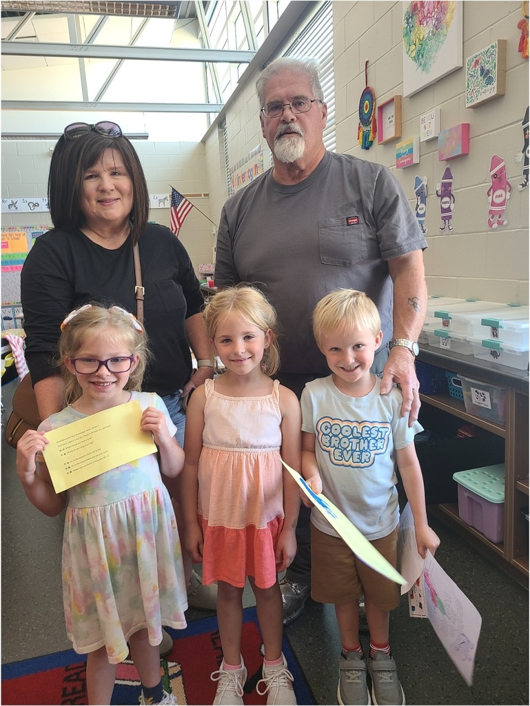 Three students standing in front of their grandparents.