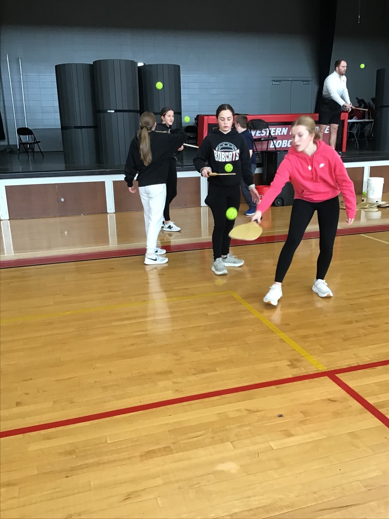 The students are learning pickleball in PE class